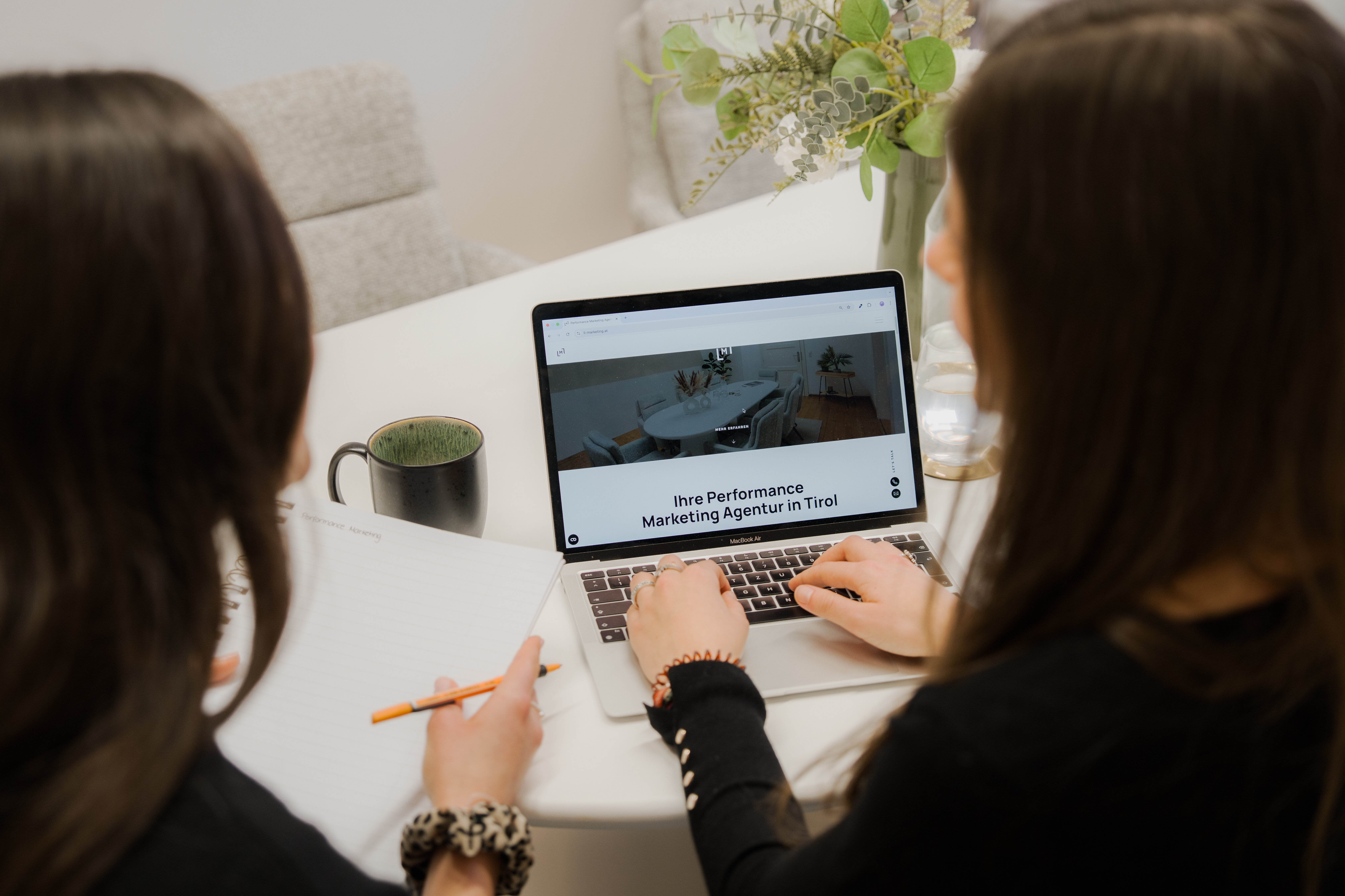 Lily und Annalena, Digital Marketing Managerinnen, schauen auf Desktop mit Website von LL-Marketing, Online-Marketing-Agentur in Tirol | © bridgeagency Janine Brugger